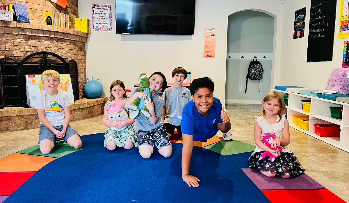 Happy students at Bright Minds Future Leaders micro school sitting on colorful carpet in classroom